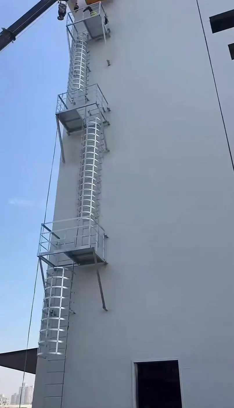 Feuerverzinkte Steigleiter-Segmente mit Rückenschutz-Bügeln im Werk